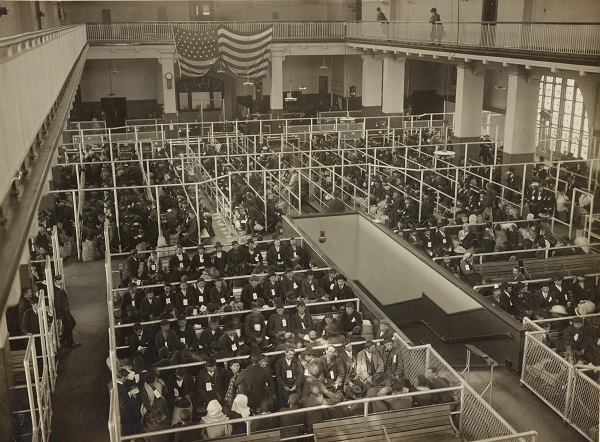 Immigrants wait in the Great Hall at Ellis Island after finishing their first mental inspection. 